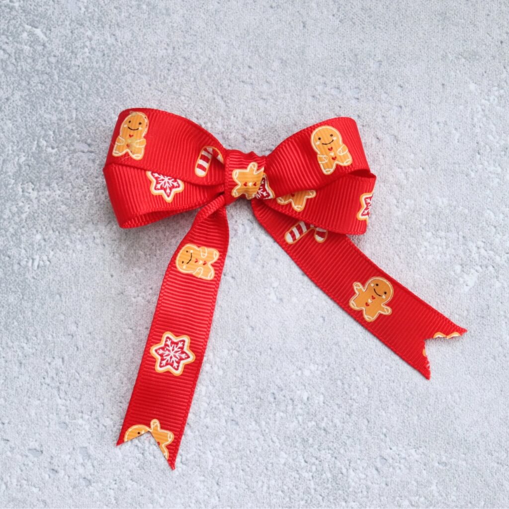 Rypsová stuha s motivem perníčků v červené barvě – ideální pro vánoční dekorace a balení dárků